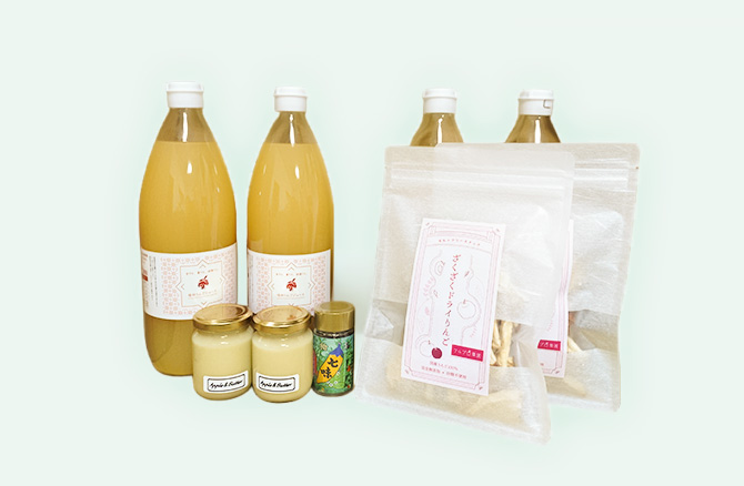 葉とらずりんごのジュース4本、りんごバター、ドライりんご、りんごスパイスが並んだギフトセットの写真。